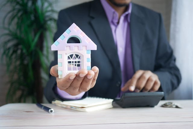 person holding a figure of a white house
