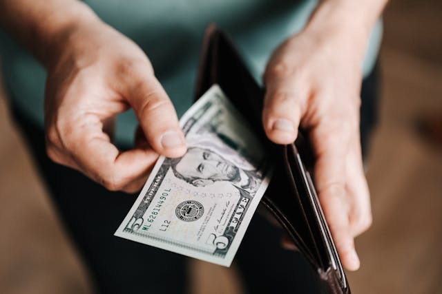 person taking money out of a wallet