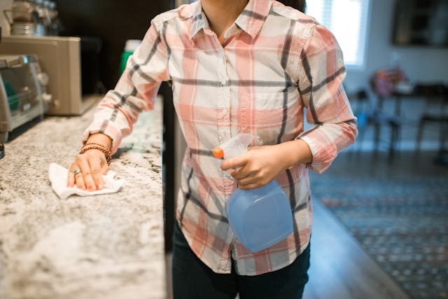 person cleaning a counter off