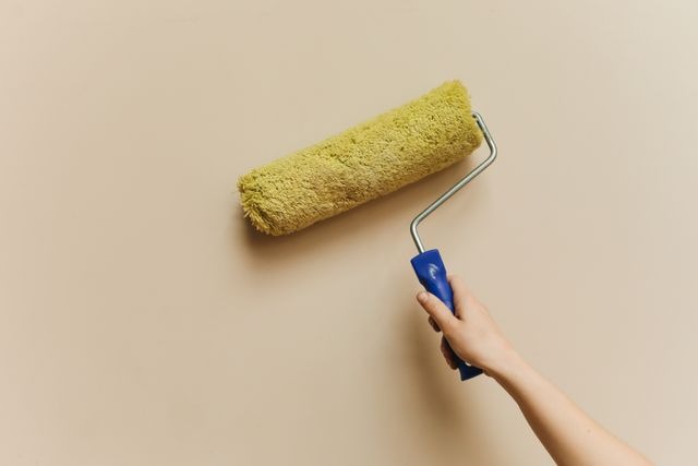 person holding a paint roller