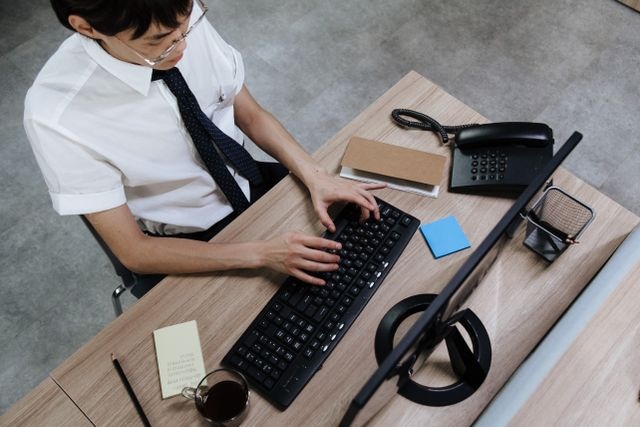 person typing on a black keyboard