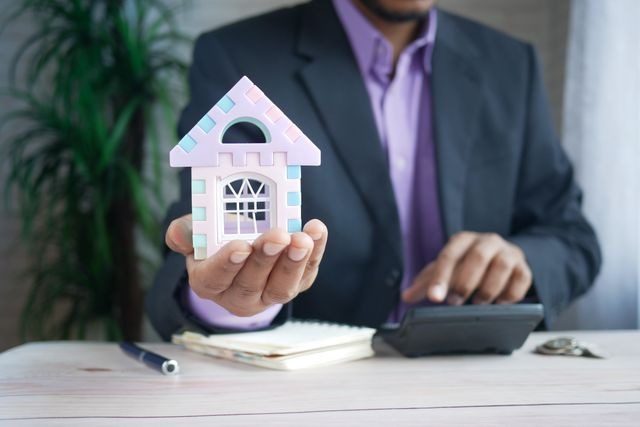 person holding a figure of a house
