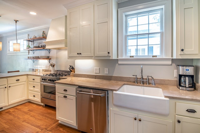 a furnished kitchen with white cabinets and stainless steal appliances