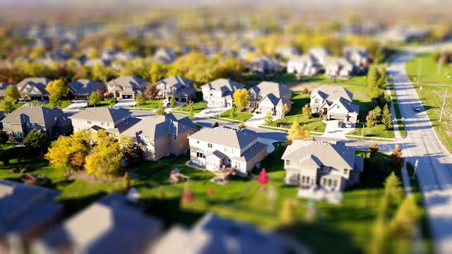 a high-angle shot of a neighborhood with green lawns