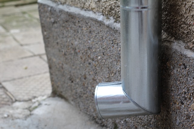 a silver downspout of a home