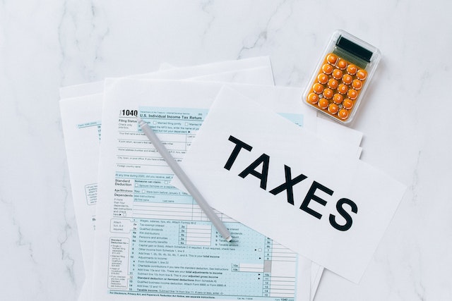 a stack of tax forms and a calculator on a white table