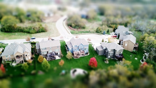 aerial shot of a neighborhood with two storey homes and lush green yards
