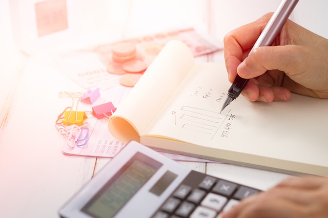 close-up-of-someone-using-a-calculator-and-notebook-to-calculate-tax-deductions