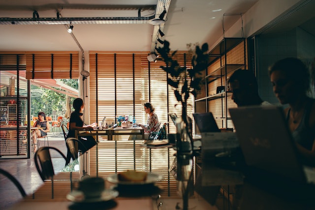 coffee shop with people on laptops working at wooden tables