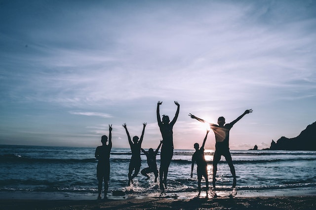 family playing at the beach near sunset