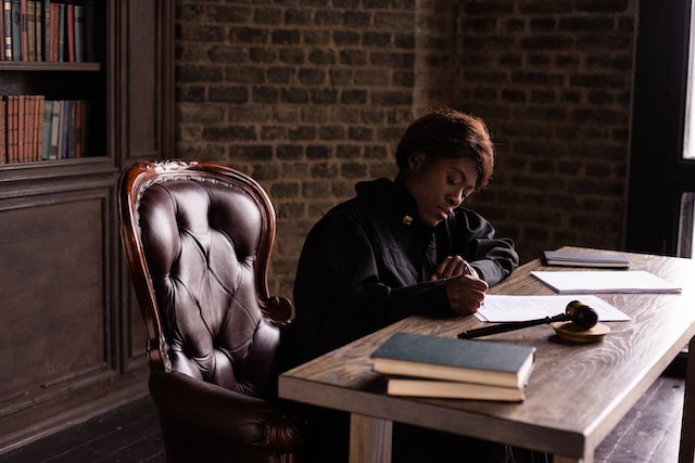 judge sitting at their desk looking over housing discrimination complaints with a gavel next to them