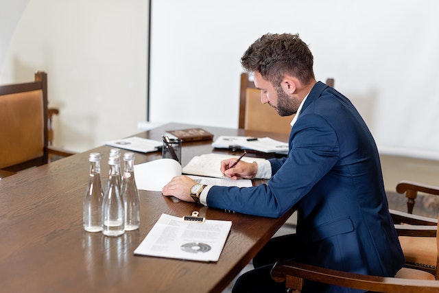 lawyer in a blue suit sitting at their desk looking over legal documents