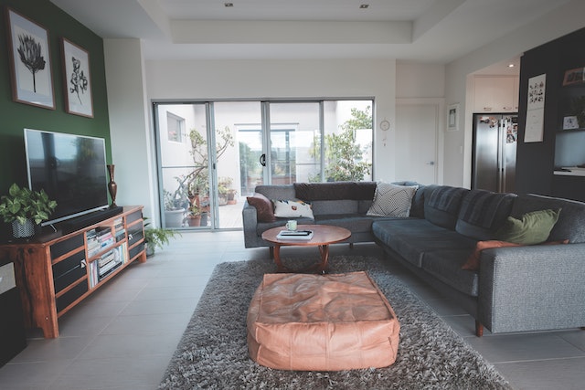 living room with dark L shaped couch and large sliding glass doors