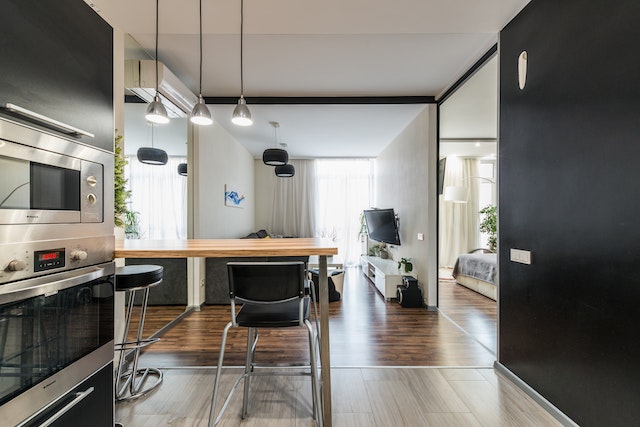 open concept black and stainless steal kitchen and living room in a modern apartment