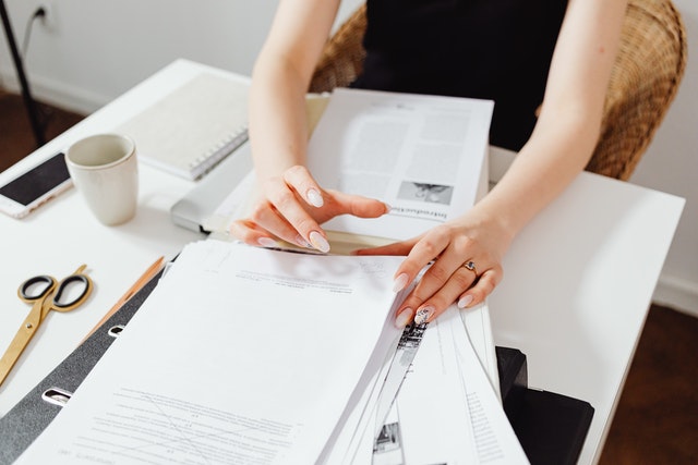 person going through a stack of papers