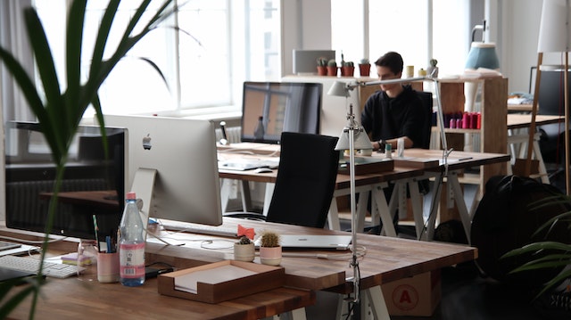 person in a large office working at on their desktop at their desk