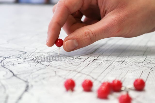 person placing a pin on a map