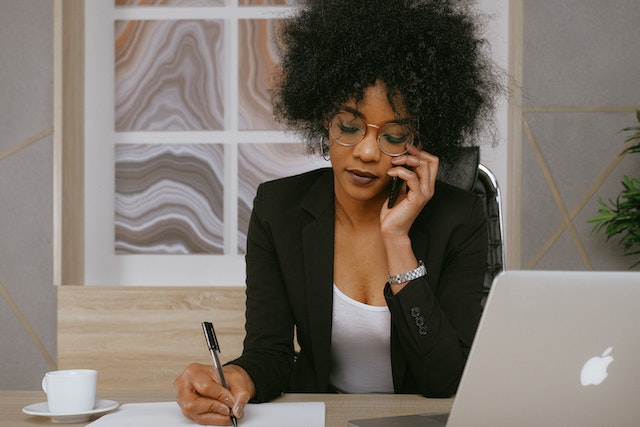 person talking on the phone and taking notes