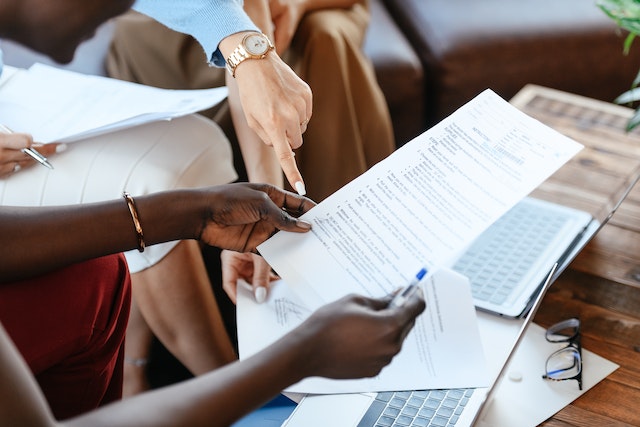 two people looking over contracts while sitting on a couch