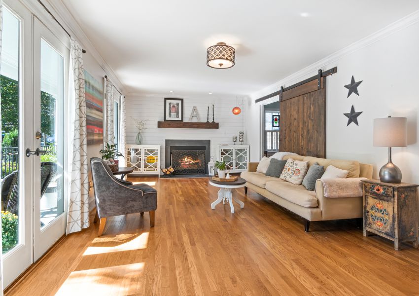 Living room with wood flooring a beige couch and barn door